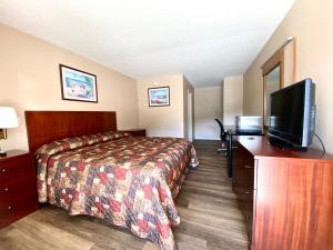 a hotel room with a bed and a flat screen tv at Economy inn in Sweetwater