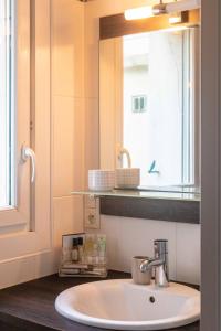 - Baño con lavabo, espejo y ventana en Brest : charmant appartement hypercentre en Brest