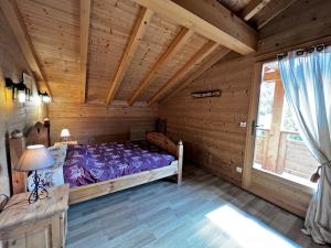 a bedroom with a bed in a log cabin at Aulp de Suz 2 - Chalet avec vue in La Clusaz