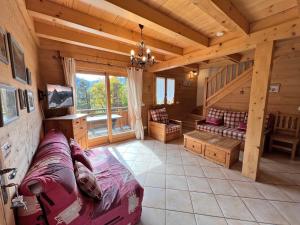 a living room with a couch and stairs in a cabin at Aulp de Suz 2 - Chalet avec vue in La Clusaz