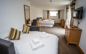 a hotel room with two beds and a television at The Windmill Inn in Watchet
