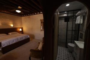 Halfeti的住宿－CEVHER KONAĞI，一间卧室配有一张床,浴室设有淋浴。