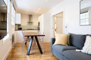 a living room with a blue couch and a table at Spacious 4 bedrooms flat in New Oxford Street in London