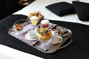 un vassoio con un vassoio di cibo su un letto di Holiday Inn Genoa City, an IHG Hotel a Genova
