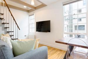 a living room with a tv and a couch at Spacious 4 bedrooms flat in New Oxford Street in London