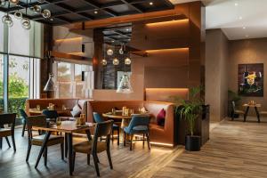a restaurant with tables and chairs in a room at Radisson Dubai Damac Hills in Dubai