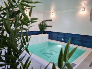 una piscina con plantas en primer plano en Les Suites du Dossen, en Santec