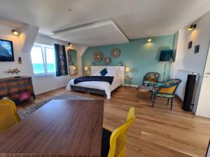 Santec的住宿－Les Suites du Dossen，卧室配有一张床和一张桌子及椅子