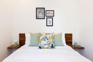 a bedroom with a bed with white sheets and pillows at Spacious 4 bedrooms flat in New Oxford Street in London
