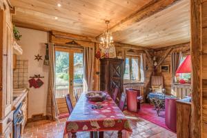 jadalnia ze stołem i krzesłami oraz drewnianym sufitem w obiekcie Appartement de l'Ours - Welkeys w mieście Megève