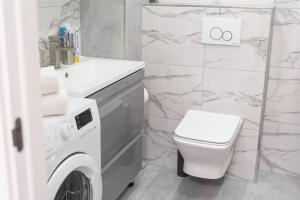 a white bathroom with a washing machine and a toilet at RentWill apartments Milky Way in Chişinău