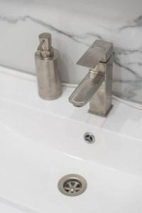 a sink with a faucet on top of it at RentWill apartments Milky Way in Chişinău