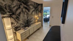 a living room with a wall mural of palm trees at Eden Park 3 pièces 4 étoiles 100m des Plages Piscines SPA Parking in Cannes