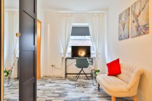 ein Wohnzimmer mit Couch und Fernseher in der Unterkunft Hotel JUMAs in Bad Zwischenahn