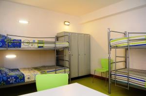 布朗庫堡的住宿－HI Castelo Branco - Pousada de Juventude，客房设有双层床和桌椅。
