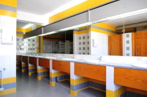 uma casa de banho com uma fila de lavatórios e espelhos em HI Castelo Branco - Pousada de Juventude em Castelo Branco