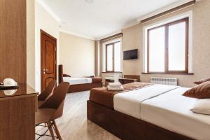 een hotelkamer met 2 bedden en een bureau bij ELDI Hotel in Tasjkent