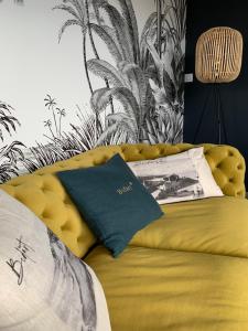 a yellow couch in a room with a palm mural at Maison d'hôtes Etxea_&_co in Bidart +6 photos