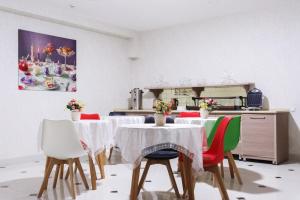 een eetkamer met tafels en stoelen met bloemen erop bij ELDI Hotel in Tasjkent