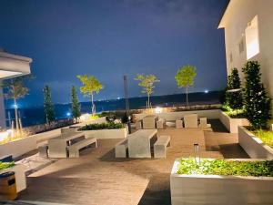 un patio con bancos y vistas al océano en IQ Homestay Cybersouth with Swimming Pool, en Kampung Dengkil