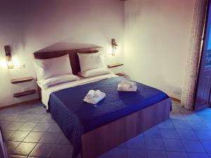 a bedroom with a bed with two slippers on it at Residenza Matilde in Fiumefreddo Bruzio