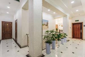 un pasillo con macetas en un edificio en ELDI Hotel, en Tashkent