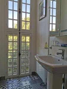 a bathroom with a sink and a large window at Château De Swann in Illiers
