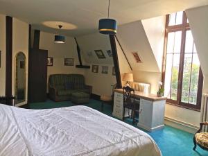 a bedroom with a bed and a desk with a chair at Château De Swann in Illiers