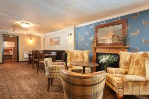 a room with a fireplace and chairs and a table at The Windmill Inn in Watchet