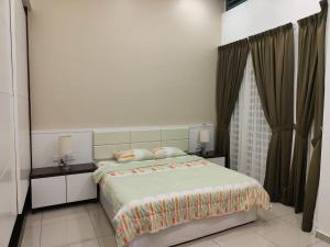 a bedroom with a bed with two tables and a window at Prestij 3 Homestay, Balik Pulau in Balik Pulau