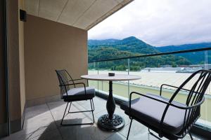 a balcony with a table and two chairs and a view at City Hotel Glarnerland in Näfels