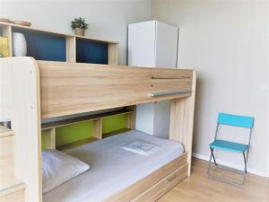 アンダイエにあるAppartement Hendaye, 2 pièces, 4 personnes - FR-1-2-351の木製の二段ベッド(青い椅子付)が備わる客室です。