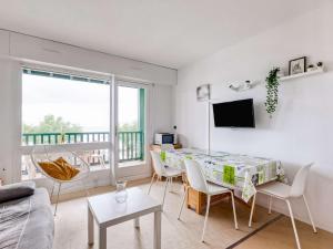 a living room with a table and chairs and a tv at Appartement Hendaye, 2 pièces, 5 personnes - FR-1-2-390 in Hendaye