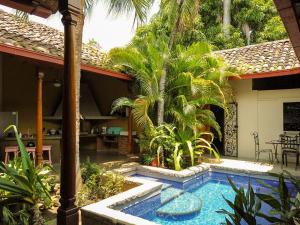 a swimming pool in front of a house with palm trees at Miskitu casa boutique in Granada