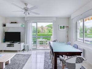 a living room with a dining room table and a television at Appartement moderne près de la plage avec balcon et Wi-Fi à Hendaye - FR-1-2-394 in Hendaye