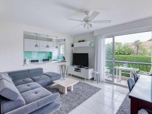 ein Wohnzimmer mit einem blauen Sofa und einem TV in der Unterkunft Appartement Hendaye, 3 pièces, 4 personnes - FR-1-2-394 in Hendaye