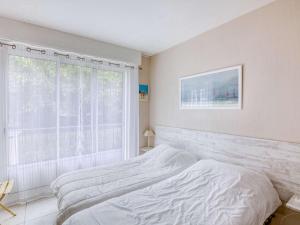 um quarto branco com uma cama e uma janela em Appartement Hendaye, 3 pièces, 4 personnes - FR-1-2-394 em Hendaye