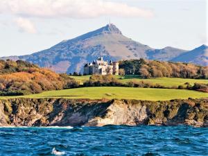 a castle on a cliff next to the water at Appartement Moderne avec Balcon, Proche Centre et Plage, Piscine et Parking, Hendaye - FR-1-2-399 in Hendaye