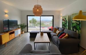 a living room with a couch and a tv at Cairnvillas Villa Essencia C45 - Luxury Villa with Private Pool near Beach in Aljezur