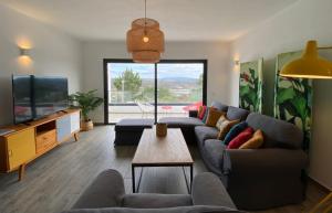 un soggiorno con un divano e una TV di Cairnvillas Villa Essencia C45 - Luxury Villa with Private Pool near Beach ad Aljezur