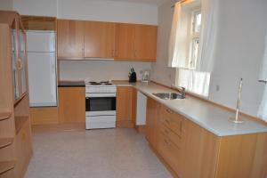 a kitchen with wooden cabinets and a white stove top oven at Motel Lido in Bredebro