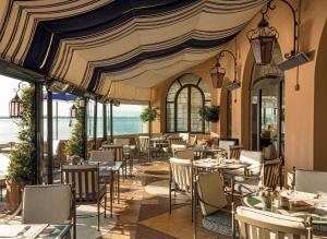 a restaurant with tables and chairs and the ocean at Hotel Cipriani, A Belmond Hotel, Venice in Venice