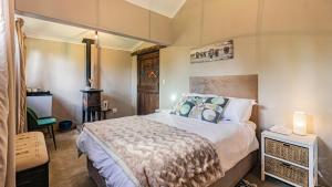 a bedroom with a large bed with blue pillows at Falling Waters in Nottingham Road