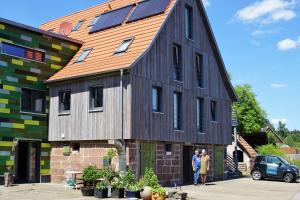 um grande edifício de madeira com painéis solares em Ausblick Maisenbach, Talstraße em Bad Liebenzell