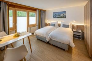 ein Hotelzimmer mit einem Bett und einem Schreibtisch in der Unterkunft Anita in Zermatt