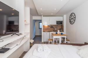 a bedroom with a white bed and a kitchen at Nice and cosy flat at the heart of Megève nearby the slopes - Welkeys in Megève