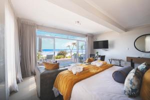 a bedroom with a large bed with a view of the ocean at Beach Villa Wilderness in Wilderness