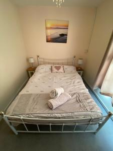 a bed with two towels on it in a room at Carlton Cottage Country Retreat - Perfect for Ipswich - Aldeburgh - Southwold - Thorpeness - Sizewell B - Sizewell C - Sleeps 13 in Little Glenham