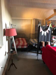 a room with two bunk beds and a red couch at Gastenverblijf op de Prins Hendrik Hoeve in Buren in Buren