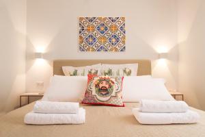 una camera da letto con un letto e due asciugamani di Duca d'Aosta Terrace, Skypool & Sauna ad Acquedolci